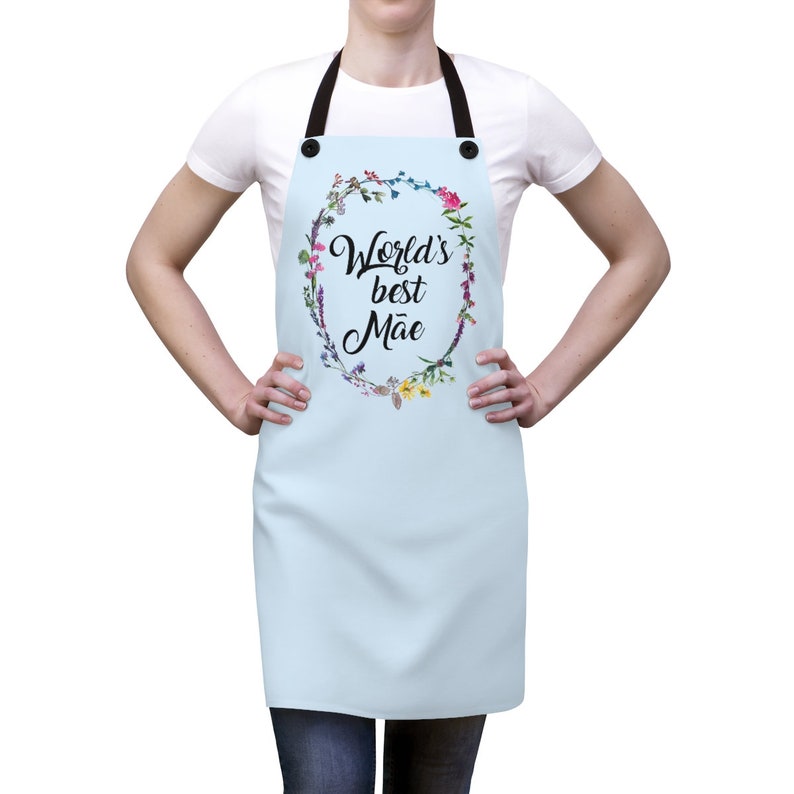 May include: A light blue apron with a floral wreath design and the text "World's best Mae".