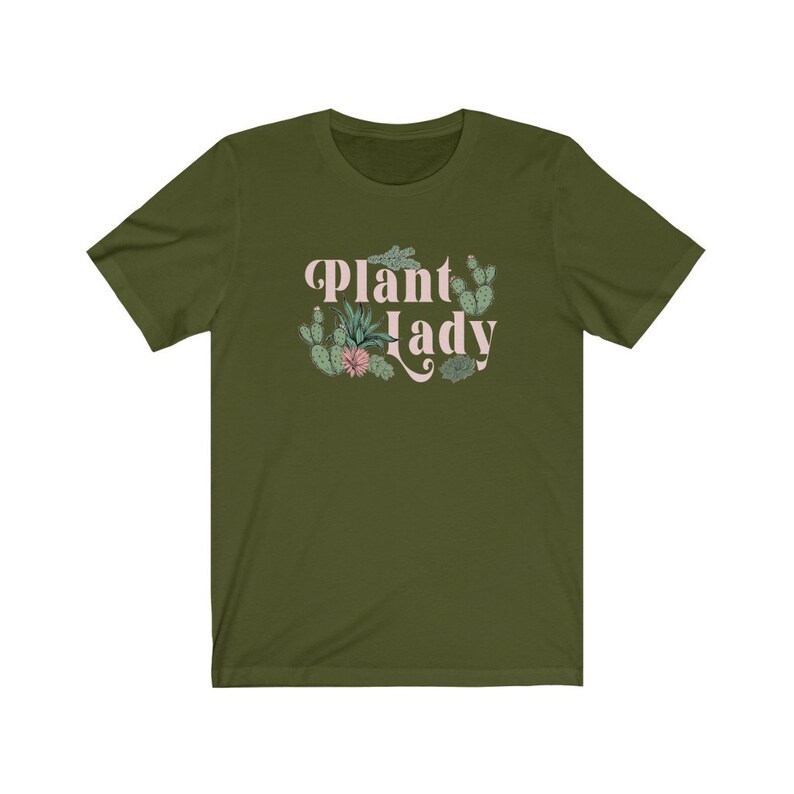May include: A green short-sleeved t-shirt with the text "Plant Lady" in pink lettering and a floral design featuring cacti and succulents.
