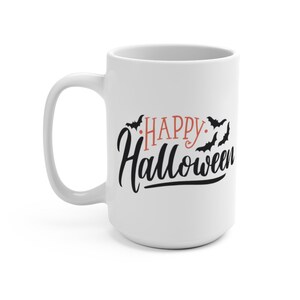 Może przedstawiać: Biały ceramiczny kubek do kawy z czarnym i pomarańczowym wzorem. Kubek ma napis "Happy Halloween" z nietoperzami latającymi wok&oacute;ł tekstu.