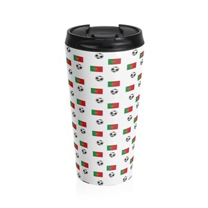 May include: A white travel mug with a black lid and a pattern of soccer balls and the Portuguese flag.