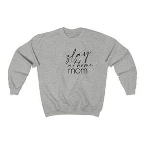 May include: Gray sweatshirt with the text "slay at home mom" in black script.