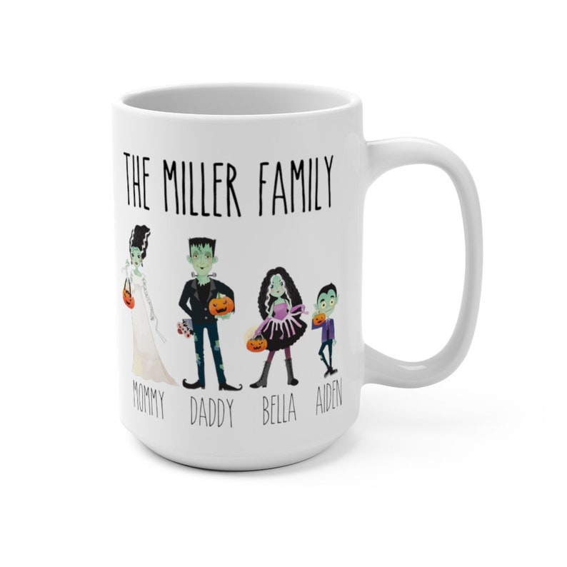 Może przedstawiać: Biały kubek ceramiczny z motywem Halloween. Przedstawia rodzinę czterech os&oacute;b przebranych za potwory, z tekstem "The Miller Family" u g&oacute;ry i "Mommy, Daddy, Bella, Aiden" na dole.