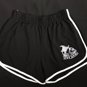 May include: Black athletic shorts with white piping around the edges. The shorts have a white embroidered design on the left leg that says "EST 2008".