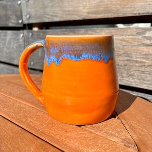 背の高いオレンジとブルーの陶器マグカップ