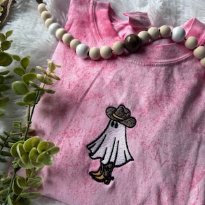 May include: Pink tie-dye t-shirt with an embroidered ghost wearing a cowboy hat.