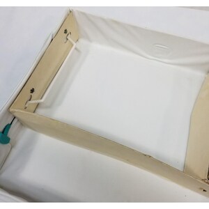 Op de afbeelding: Een open, rechthoekige opbergdoos met een wit interieur en een beige frame. De doos heeft een stoffen voering en is ontworpen voor het organiseren van items. De doos is leeg en klaar voor gebruik.