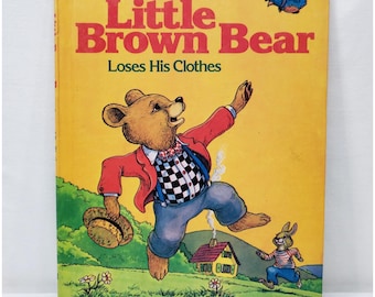 May include: A vintage children's book titled "Little Brown Bear Loses His Clothes" by Elizabeth Upham. The cover features a cartoon bear in a red jacket and checkered bow tie, with a rabbit and a blue bird. The book has a yellow background.