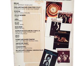 May include: Vintage sheet music titled "Harmonica Music Pops No. 3" arranged for chromatic and diatonic harmonica. The cover features a list of songs and album art from various artists, including ABBA, Stevie Wonder, and Bread.