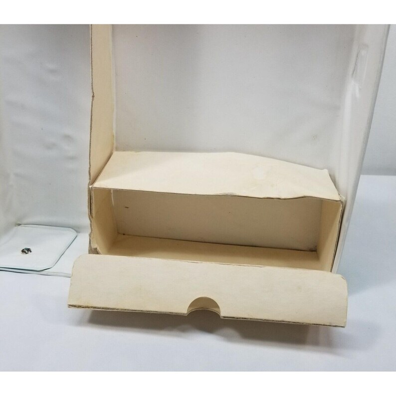 Op de afbeelding: Een open, lege kartonnen doos met een lichtbeige binnen- en buitenkant. De doos heeft een rechthoekige vorm met een deksel dat openklapt. De doos staat op een wit oppervlak.