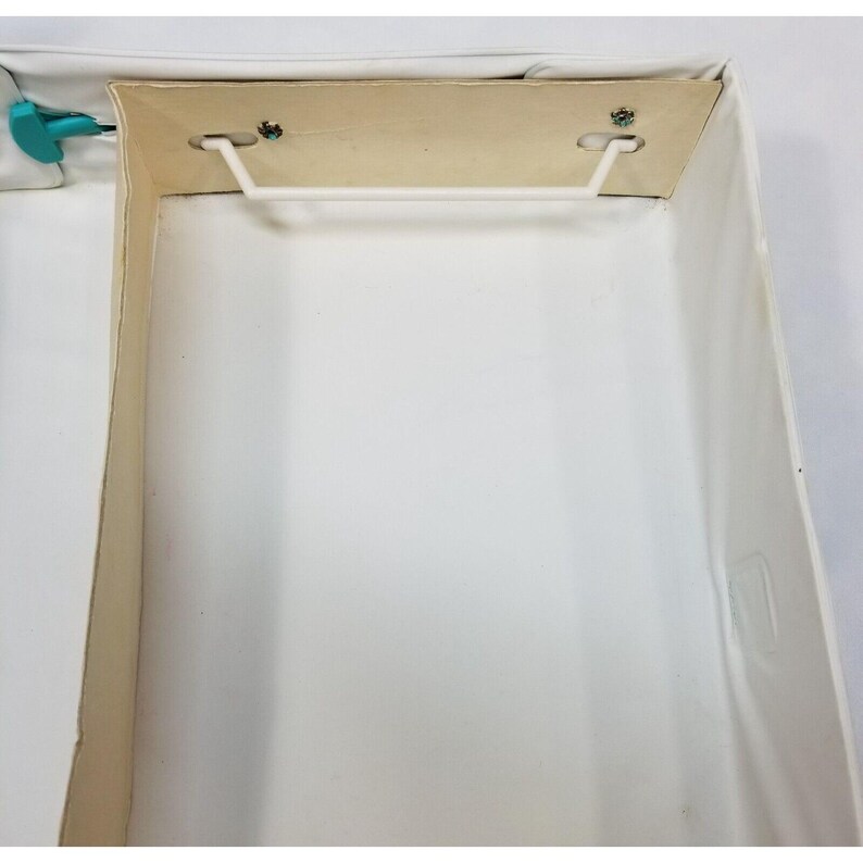 Op de afbeelding: Een open, lege witte doos met een lichtbruin interieur. De doos heeft een witte plastic handgreep en is gemaakt van karton. De doos is rechthoekig en heeft een eenvoudig ontwerp.