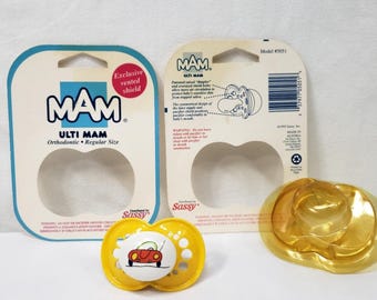 May include: A yellow MAM Ulti pacifier with a car graphic, packaged with its original backing. The packaging includes the MAM logo, product information, and the words "Exclusive vented shield".