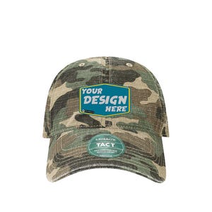 May include: A camouflage baseball cap with a blue and white patch that says "YOUR DESIGN HERE". The cap also has a small black and white label that says "LEGACY TACT" with the text "HIGH-GRADE MADE WITH FRESH RECYCLED CONTENT".