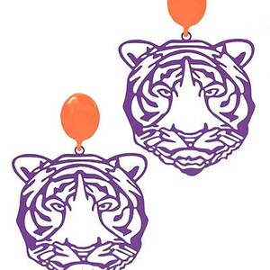 May include: Purple tiger face earrings with orange balloon charms.