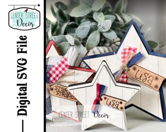 May include: Three wooden stars with red, white, and blue accents. The stars have a distressed white paint finish and are decorated with red and blue ribbon, gingham fabric, and wooden tags that say "USA".