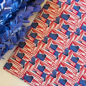 May include: Red, white, and blue fabric with a repeating pattern of distressed American flags. The fabric has a white background with red and blue stripes and white stars.