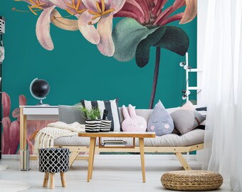 Può includere: Un muro turchese con un grande murale floreale con fiori rosa e rossi. Un divano grigio chiaro con cuscini e un tavolino da caffè si trovano di fronte al muro.