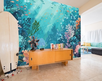 May include: A room featuring a vibrant underwater-themed mural with coral, fish, and bubbles. A surfboard leans against the wall. A wooden cabinet holds a fan and books. The room has a light, airy feel.