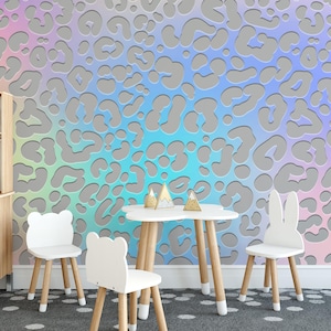 Op de afbeelding: Een speelkamer met een kleurrijk behang met dierenprint, een witte tafel met vier witte stoelen en een klein keukengedeelte met een gootsteen en kasten.