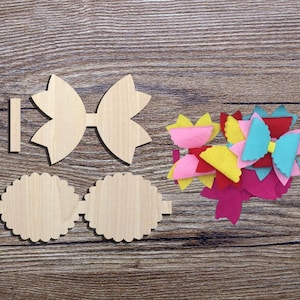 Puede incluir: Formas de madera de lazo y círculo para manualidades, junto con una pila de tela de fieltro en rosa, amarillo, rojo y azul.