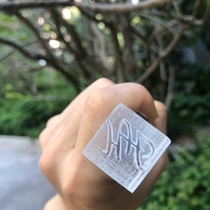 May include: A clear square stamp with the word "HAP" engraved in a cursive font.