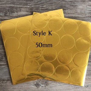 以下が含まれることがあります： 丸い円の金箔ステッカーが2枚。ステッカーの直径は50mmで、「Style K 50mm」とラベル付けされています。