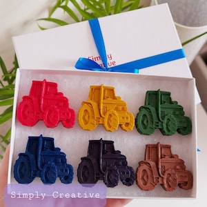 May include: Six colorful toy tractors in a box. The tractors are red, yellow, green, blue, purple, and brown. The box has the words "Simply Creative" printed on the front.