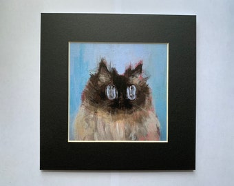 May include: A framed painting of a cat with blue eyes. The cat is painted in a realistic style with a soft, muted color palette.