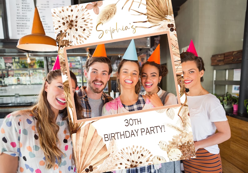 May include: A photo booth prop with a white background and brown floral designs. The text "Sophia's 30th Birthday Party!" is printed on the prop.