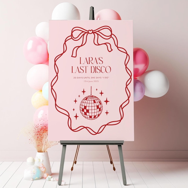 May include: A pink sign with a red border and a red bow at the top. The sign says "Lara's Last Disco" and "20 days until she says "I do" 13th June 2023". A red disco ball with stars is in the center of the sign.
