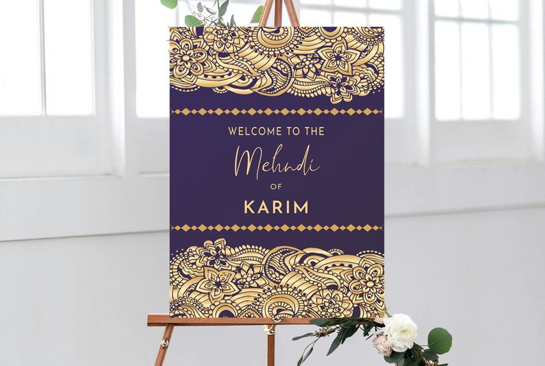 May include: Purple and gold welcome sign with intricate floral designs. The sign reads "Welcome to the Mehndi of Karim".