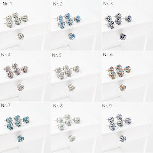 Peut inclure: Neuf ensembles de boutons de tiroir en céramique avec différents motifs floraux. Chaque ensemble comprend trois boutons avec une base argentée et un motif floral décoratif. Les boutons sont disposés en rangées, numérotées de 1 à 9.