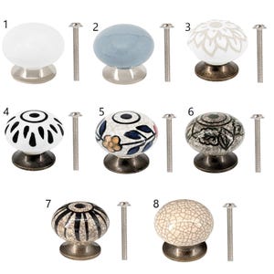 Op de afbeelding: Acht keramische kastknoppen met verschillende patronen en kleuren. De knoppen zijn rond en hebben een metalen basis. Elke knop wordt geleverd met een zilveren schroef.