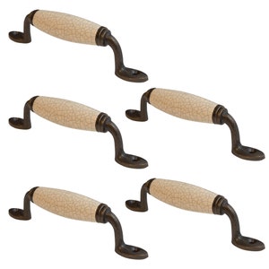 Peut inclure: Ensemble de cinq poignées de porte de placard en céramique avec une finition blanche craquelée et des accents métalliques bronze antique. Chaque poignée mesure environ 10 cm de long.
