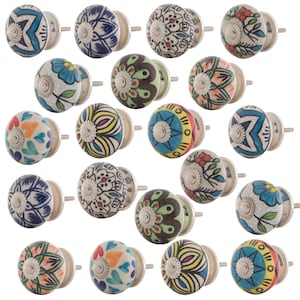 May include: A collection of twenty round ceramic cabinet knobs featuring various hand-painted patterns including floral, star, and heart motifs in vibrant colours like blue, red, yellow, green, and black, each with a silver-toned metal mounting bolt.