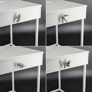 May include: Four white bedside tables with decorative drawer pulls. The pulls are shaped like an owl, a bird, a dinosaur, and a butterfly. The tables have white metal legs.