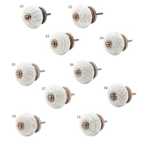 Può includere: Dieci pomelli per mobili in ceramica bianca con diversi disegni in rilievo. Ogni pomello ha una vite in ottone ed è numerato da 01 a 10.