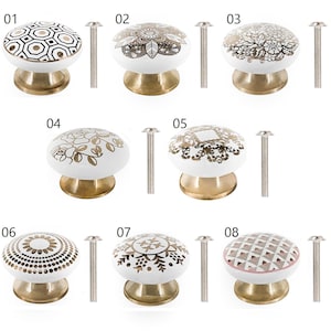 May include: Eight white ceramic cabinet knobs with gold and pink designs. Each knob has a brass base and comes with a silver screw.