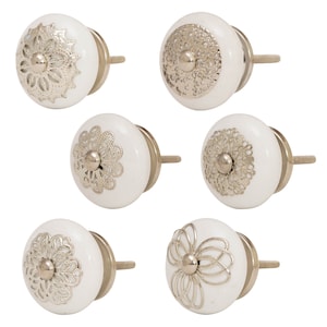 May include: Six white ceramic cabinet knobs with silver metal accents. Each knob features a different intricate floral design.
