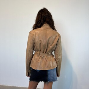 K&ouml;nnte beinhalten: Eine braune Lederjacke mit G&uuml;rtelbund. Die Jacke hat eine leicht taillierte Silhouette und lange &Auml;rmel.