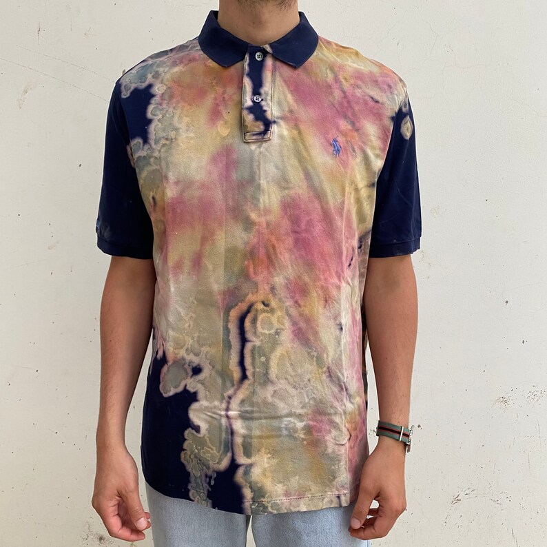 May include: A blue and white tie-dye polo shirt with a small embroidered logo on the chest.