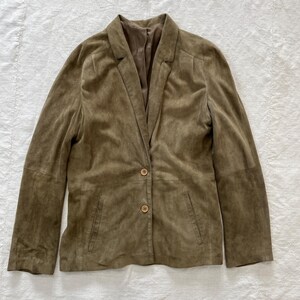May include: A brown suede blazer with a notched collar and three button closure.