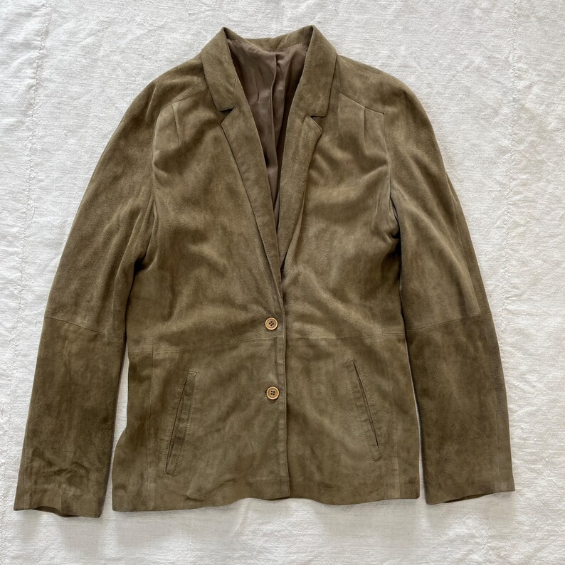 May include: A brown suede blazer with a notched collar and three button closure.