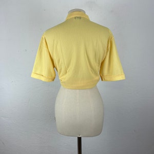 May include: A yellow ribbed short-sleeved crop top with a collared neckline.