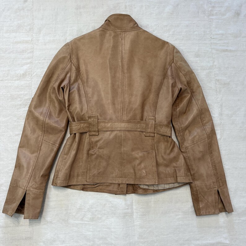K&ouml;nnte beinhalten: Eine braune Lederjacke mit G&uuml;rtel und Stehkragen.