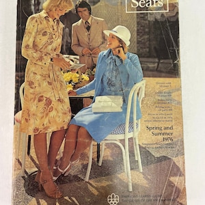 May include: A vintage Sears catalog cover from 1976 featuring a woman in a floral dress and a woman in a blue dress sitting at a table. The text on the cover reads "Spring and Summer 1976" and "Simpsons-Sears Limited Regina, Saskatchewan".