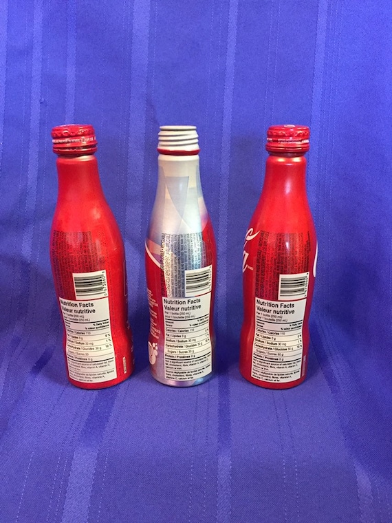Coca Cola Aluminum Bottles. 3 Assorted. 1 Plain Unopened. 1 Torch