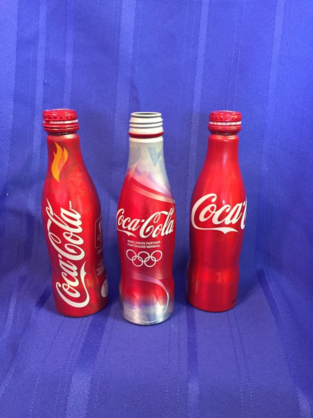 Coca Cola Aluminum Bottles. 3 Assorted. 1 Plain Unopened. 1 Torch