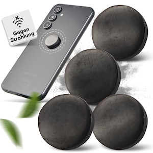 Puede incluir: Cuatro discos redondos negros con un teléfono Samsung plateado en el fondo. El teléfono tiene una funda negra y una pegatina circular plateada en la parte posterior. El texto "Gegen Strahlung" es visible en un cuadrado blanco en la esquina superior izquierda de la imagen.