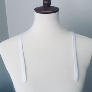 Detachable straps.   White 1/2 inch wide soft satin straps.