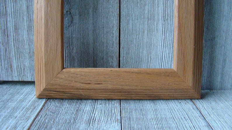 May include: A simple, rectangular wooden picture frame with a natural wood finish.